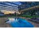 Beautiful screened-in pool area, showcasing a relaxing backyard setting with comfortable lounge seating and a stone water feature at 25859 Crossings Bluff Ln, Sorrento, FL 32776