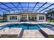 A screened-in pool area with a tile surround and a glimpse of the home's exterior, ideal for enjoying sunny days at 25859 Crossings Bluff Ln, Sorrento, FL 32776