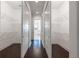 Hallway view into dual walk-in closets featuring shelving and hardwood floors at 25859 Crossings Bluff Ln, Sorrento, FL 32776