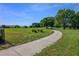 Scenic community walking path surrounded by lush green grass and mature trees on a clear day at 25859 Crossings Bluff Ln, Sorrento, FL 32776
