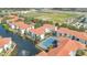 Aerial view of community featuring tennis court, lake with fountain, mature trees, and red-tiled roofs at 2627 Maitland Crossing Way # 101, Orlando, FL 32810