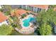 An aerial shot features a community pool with chairs and tables surrounded by shady trees and a lake at 2627 Maitland Crossing Way # 101, Orlando, FL 32810