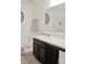 Well-lit bathroom featuring a dark vanity with white countertop and a large mirror at 2835 Mosshire Cir, St Cloud, FL 34772