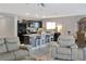 Open-concept living room and kitchen with an island, black appliances, and modern finishes at 2835 Mosshire Cir, St Cloud, FL 34772