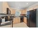 Bright kitchen with tile floors, wooden cabinets and black appliances at 2915 Hargill Dr, Orlando, FL 32806