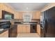 Functional kitchen featuring tile floors, wooden cabinets and black appliances at 2915 Hargill Dr, Orlando, FL 32806