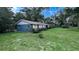 Single-story home featuring a blue exterior, well-manicured lawn, and lush landscaping, offering a tranquil setting at 2928 Ne 14Th Ave, Ocala, FL 34479