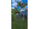Side yard with chain link fence, lush lawn, and exterior view of the home, trashcans at 2928 Ne 14Th Ave, Ocala, FL 34479