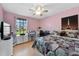 Bedroom with pink walls, ceiling fan, storage drawers, and a window at 2966 Derby Dr, Deltona, FL 32738