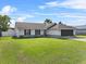 Well-kept single-story home featuring a lush green lawn and an attached screened garage at 2966 Derby Dr, Deltona, FL 32738