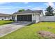 Rear view of home showing the screened garage, manicured lawn and privacy fence at 2966 Derby Dr, Deltona, FL 32738