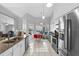 Bright kitchen features stainless steel appliances, granite counters, and white cabinets and tiled flooring at 2966 Derby Dr, Deltona, FL 32738