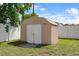 Small backyard storage shed with white doors at 2966 Derby Dr, Deltona, FL 32738