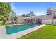 Spacious backyard featuring a sparkling pool, lush green grass, and an inviting sunroom at 315 Pickering Ct, Longwood, FL 32779