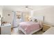 Bright bedroom features wood floors, a cozy bed with purple linens, and window with sheer curtains at 315 Pickering Ct, Longwood, FL 32779