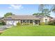 Charming single-story home with a well-manicured lawn, complemented by lush landscaping and a welcoming front porch at 315 Pickering Ct, Longwood, FL 32779