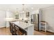 Bright kitchen features white cabinetry, stainless appliances, quartz counters, and a large central island with seating at 315 Pickering Ct, Longwood, FL 32779