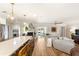 An open kitchen features white cabinetry, stainless appliances, quartz counters, and is open to the living room at 315 Pickering Ct, Longwood, FL 32779
