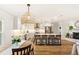 Modern, all-white kitchen featuring a large island with bar seating and stainless steel appliances at 315 Pickering Ct, Longwood, FL 32779