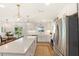 Bright kitchen features white cabinetry, stainless appliances, quartz counters, and a large central island with seating at 315 Pickering Ct, Longwood, FL 32779