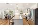 A bright kitchen with white cabinets and stainless appliances connects to an adjacent dining area with natural light at 315 Pickering Ct, Longwood, FL 32779