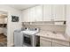 Bright laundry room features modern washer and dryer units, a utility sink, and ample white cabinet storage at 315 Pickering Ct, Longwood, FL 32779