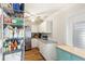 Pantry with plentiful dry food storage, stainless refrigerator, and white cabinets with granite countertops at 315 Pickering Ct, Longwood, FL 32779
