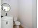 Clean powder room with a modern vanity, black faucet, round mirror, and ceramic toilet at 33 W 7Th St, Apopka, FL 32703