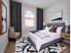 Modern bedroom with neutral walls, wood floor, area rug, large window, and custom dark gray drapes at 33 W 7Th St, Apopka, FL 32703
