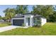 Well-manicured lawn and appealing exterior of single-Gathering home featuring modern design, a two-car garage, and lovely landscaping at 33 W 7Th St, Apopka, FL 32703