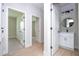 Bright hallway with access to a modern bathroom featuring a vanity and round mirror at 33 W 7Th St, Apopka, FL 32703