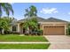 Charming single-story home with a well-manicured lawn, lush landscaping, and an attached two-car garage at 3304 Bennington Ct, Winter Park, FL 32792