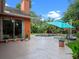Backyard featuring a pool, blue umbrella, lush landscaping and a stained concrete patio at 3518 Edlingham Ct, Belle Isle, FL 32812