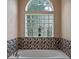 Bright bathroom featuring a mosaic tile backsplash, glass block window, and a soaking tub at 3518 Edlingham Ct, Belle Isle, FL 32812