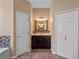 Bathroom with a dark vanity, tiled floor, large mirror and two white doors on either side at 3518 Edlingham Ct, Belle Isle, FL 32812