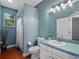 Bathroom with turquoise colored walls, a shower and a light colored cabinet at 3518 Edlingham Ct, Belle Isle, FL 32812