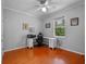 Bedroom with grey walls, a ceiling fan, light trim, hardwood floors and a window at 3518 Edlingham Ct, Belle Isle, FL 32812