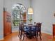 Bright dining room featuring a large window, wooden table with blue upholstered chairs, and hardwood floors at 3518 Edlingham Ct, Belle Isle, FL 32812