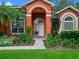 Inviting front entrance featuring an arched doorway and lush garden at 3518 Edlingham Ct, Belle Isle, FL 32812