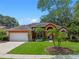 Charming one-story home with a beautiful front lawn, palm trees, and an attached two-car garage at 3518 Edlingham Ct, Belle Isle, FL 32812