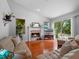 Bright living room featuring hardwood floors, a stone fireplace, and access to the outdoor patio at 3518 Edlingham Ct, Belle Isle, FL 32812