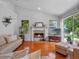 Cozy living room featuring a stone fireplace, hardwood floors, and a sliding door to the backyard at 3518 Edlingham Ct, Belle Isle, FL 32812