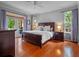 Bright main bedroom with wooden floors, natural light, and access to the pool through French doors at 3518 Edlingham Ct, Belle Isle, FL 32812