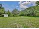 Expansive backyard with lush green grass and mature trees, providing ample space at 455 Orange Ave, St Cloud, FL 34769