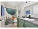 Bathroom featuring green vanity with gray countertop, modern sink, and geometric shower curtain at 455 Orange Ave, St Cloud, FL 34769