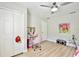 Bedroom featuring light hardwood floors, a ceiling fan, and a vanity table with pink roller chair at 455 Orange Ave, St Cloud, FL 34769