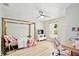 Bright bedroom with a four-poster bed, ceiling fan, and bright natural light at 455 Orange Ave, St Cloud, FL 34769