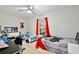 Bedroom featuring a gray ceiling fan and a bed with a racecar bed, and bright red curtains at 455 Orange Ave, St Cloud, FL 34769