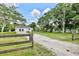 Long private gravel driveway surrounded by mature trees and lush greenery at 455 Orange Ave, St Cloud, FL 34769