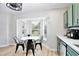 Bright kitchen nook featuring a white table, black chairs, and a view of the backyard at 455 Orange Ave, St Cloud, FL 34769